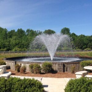 An Otterbine aerating fixed fountain in the middle of a small oval pond.
