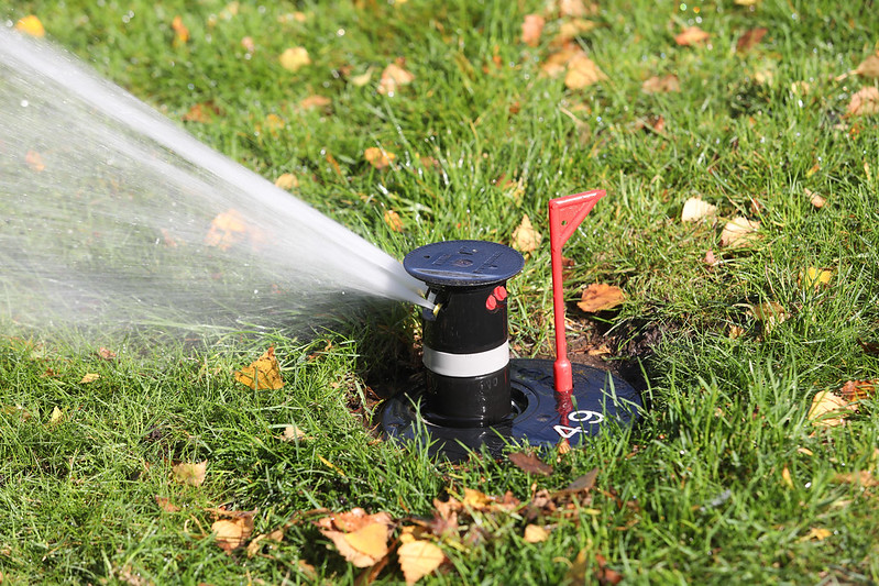 A close up of a Toro irrigation sprinkler in operation.